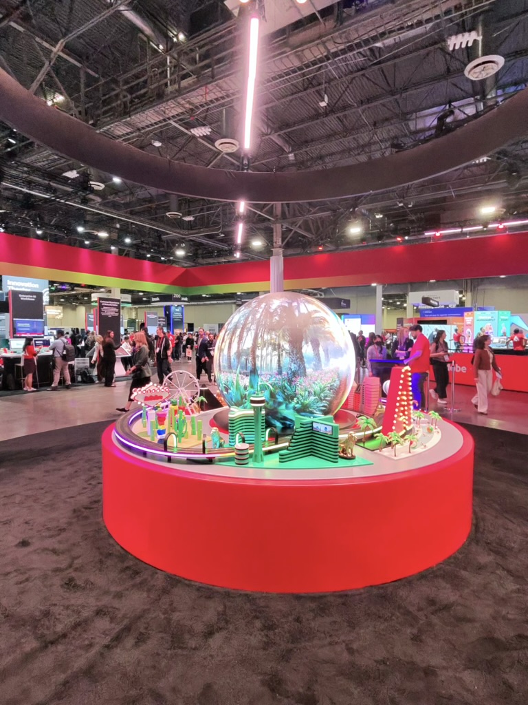 Adobe Summit 2026 show floor — mirrored globe installation with miniature landscape